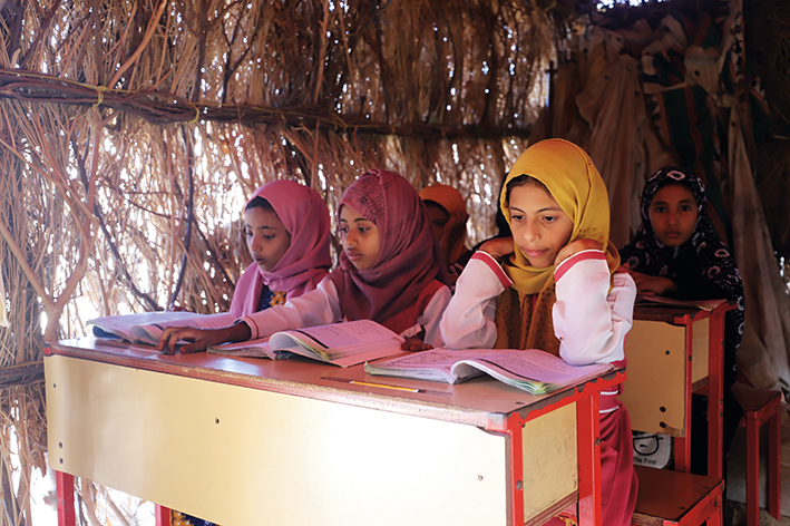 孩子們在也門北部哈杰省一所學校的茅草屋里上課